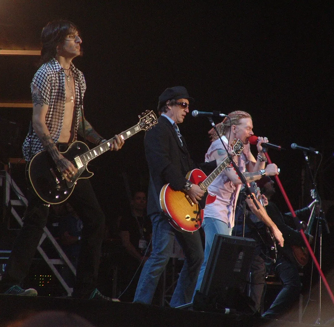 Guns N' Roses on stage at Download Festival 2006: guitarists Richard Fortus and Izzy Stradlin with Axl Rose at the microphone.