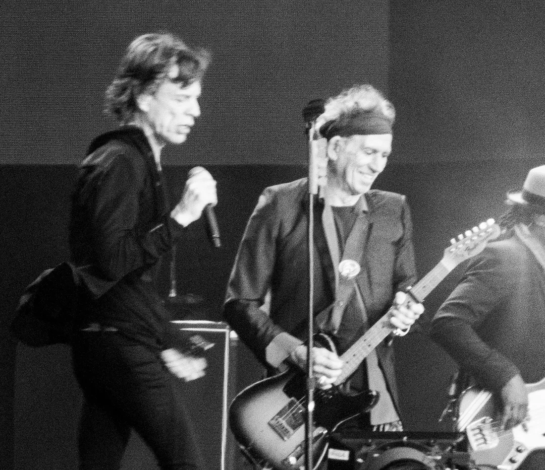 Black-and-white photo of Mick Jagger singing and Keith Richards playing guitar on stage at BST Hyde Park in July 2013.