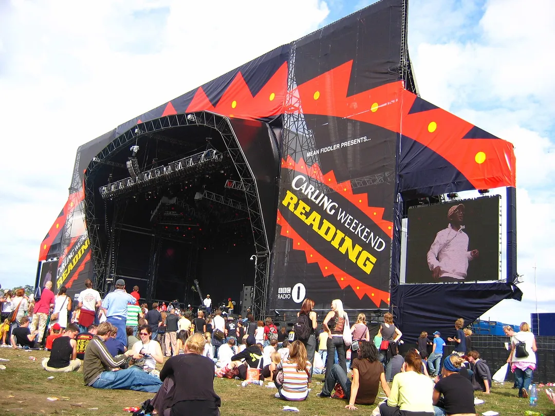 The main stage at Reading Festival in 2005, branded Carling Weekend, with a crowd sitting and standing on the grass in front.