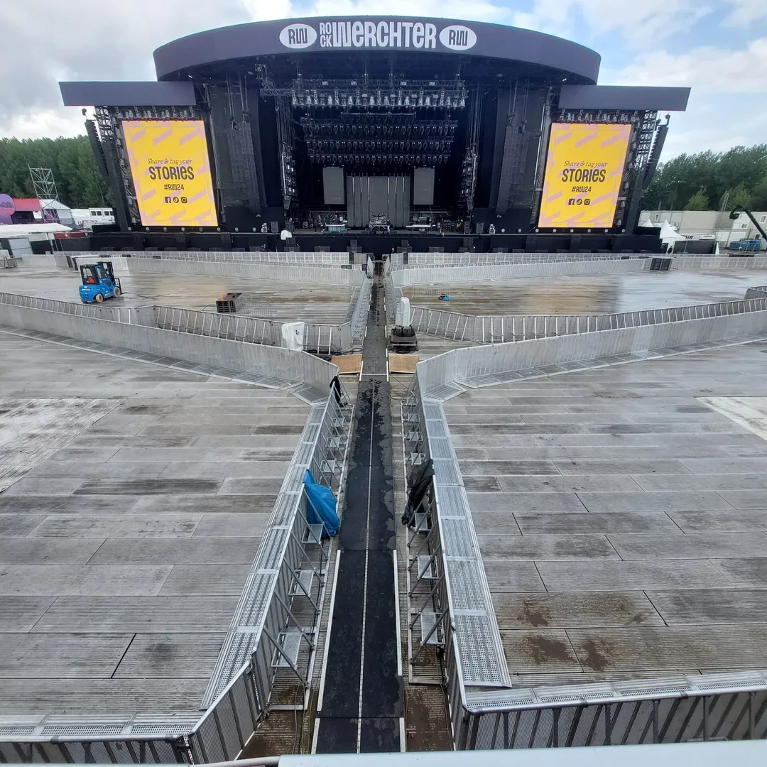 The empty main-stage arena at Rock Werchter before the gates open, with barrier pens and a central gangway running out from the stage.