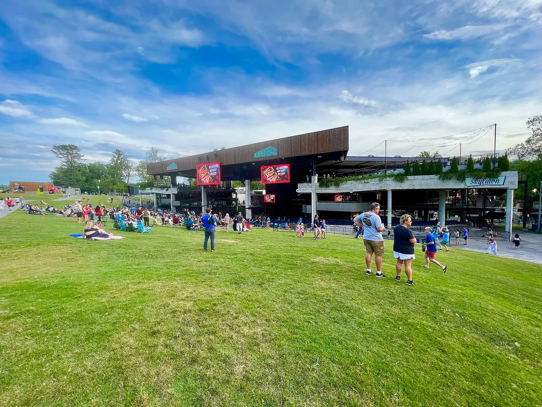 The view from the lawn at Merriweather Post Pavilion: a grassy slope leading down to the covered pavilion and stage.